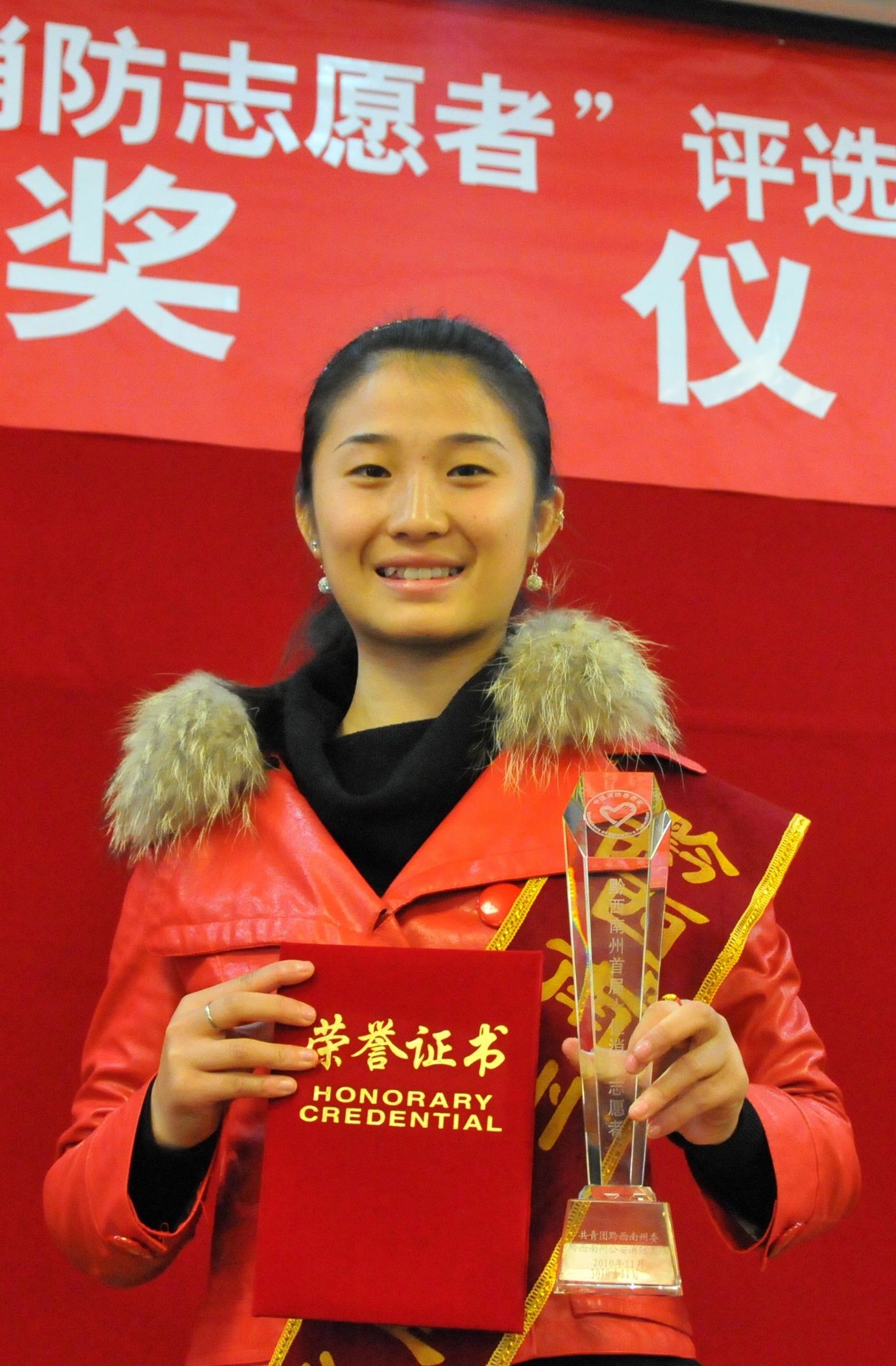 当选十佳消防志愿者王婷婷高兴地展示自己的证书和奖杯.jpg