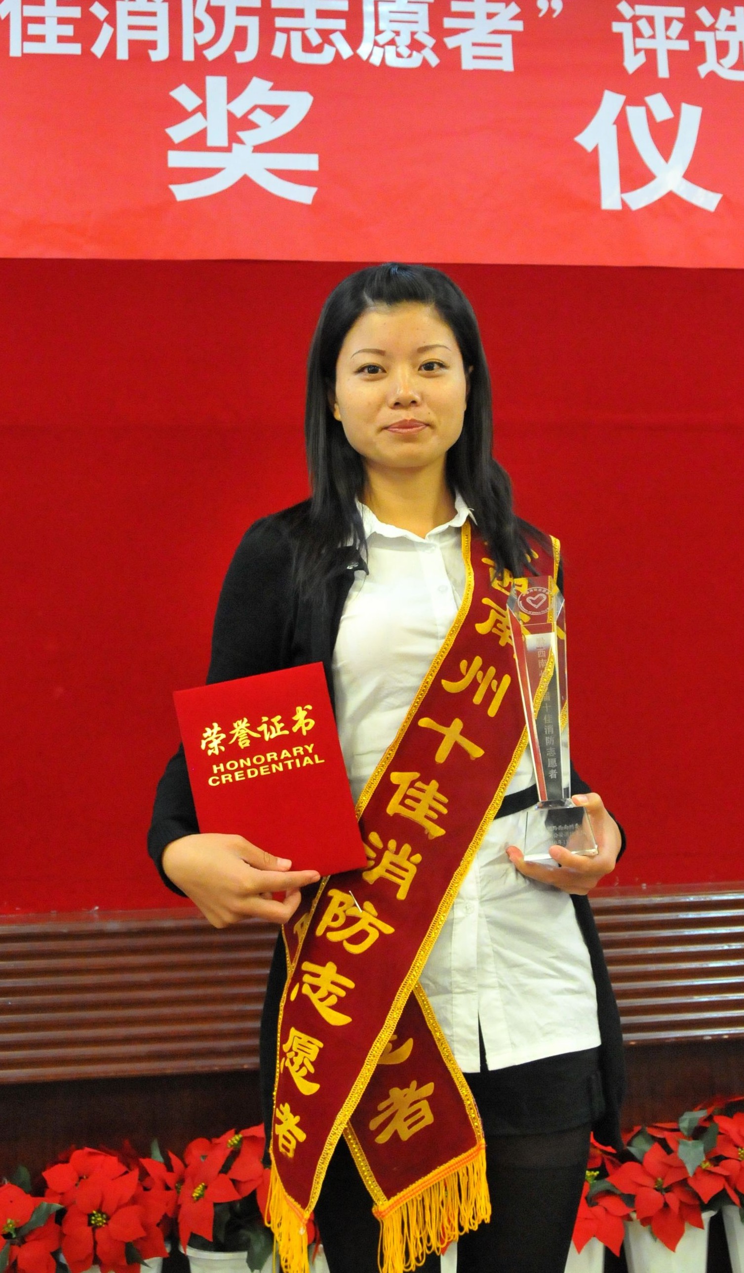 当选十佳消防志愿者唐棠高兴地展示自己的证书和奖杯.jpg