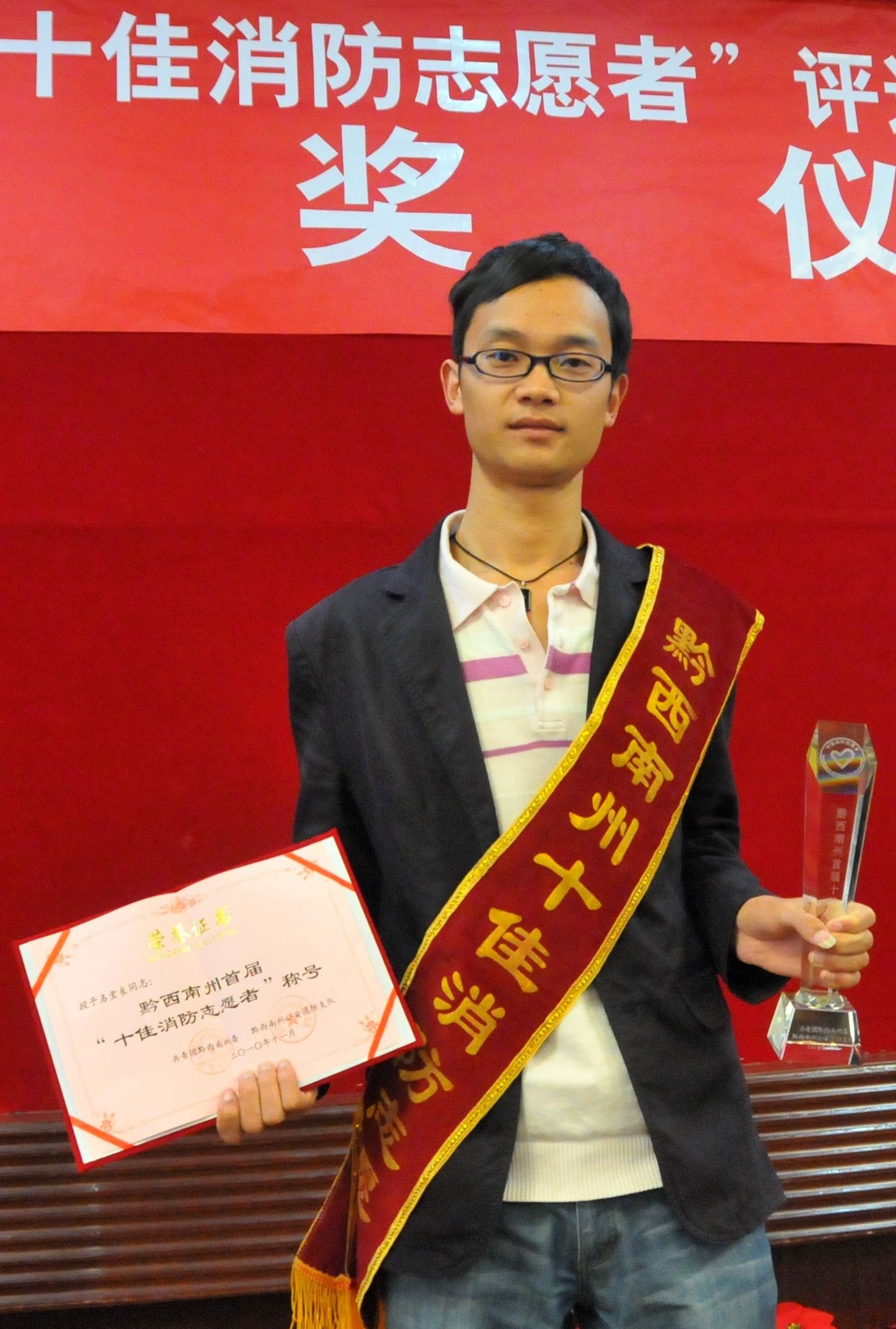 当选十佳消防志愿者马宏良高兴地展示自己的证书和奖杯.jpg