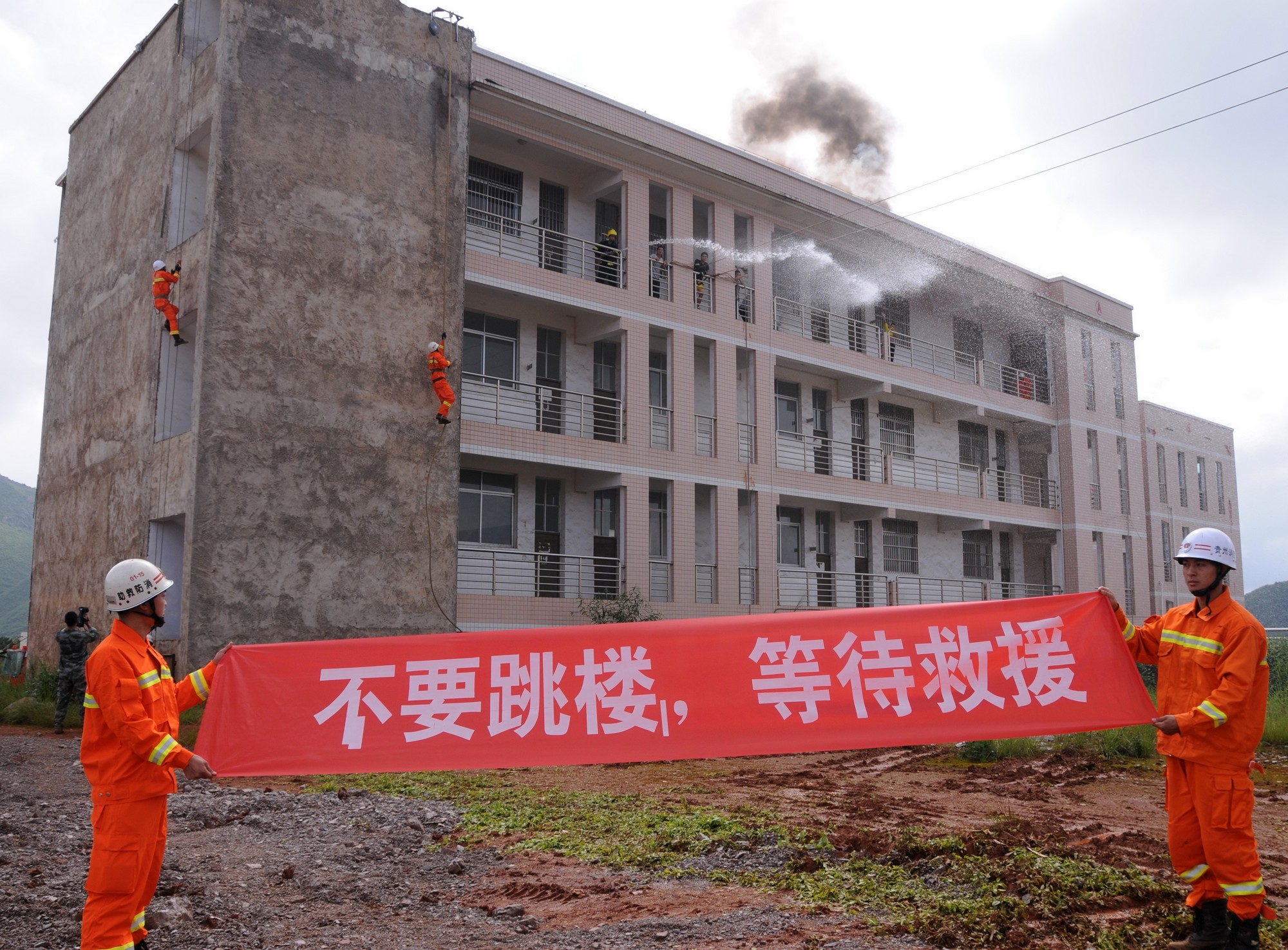 06 演练现场消防官兵打出标语和喊话请被困人员不要盲目跳楼.JPG