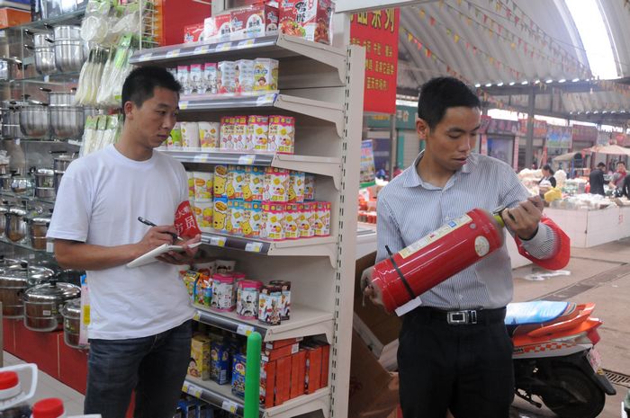 义务消防员对超市过期失效的消防器材进行登记.jpg
